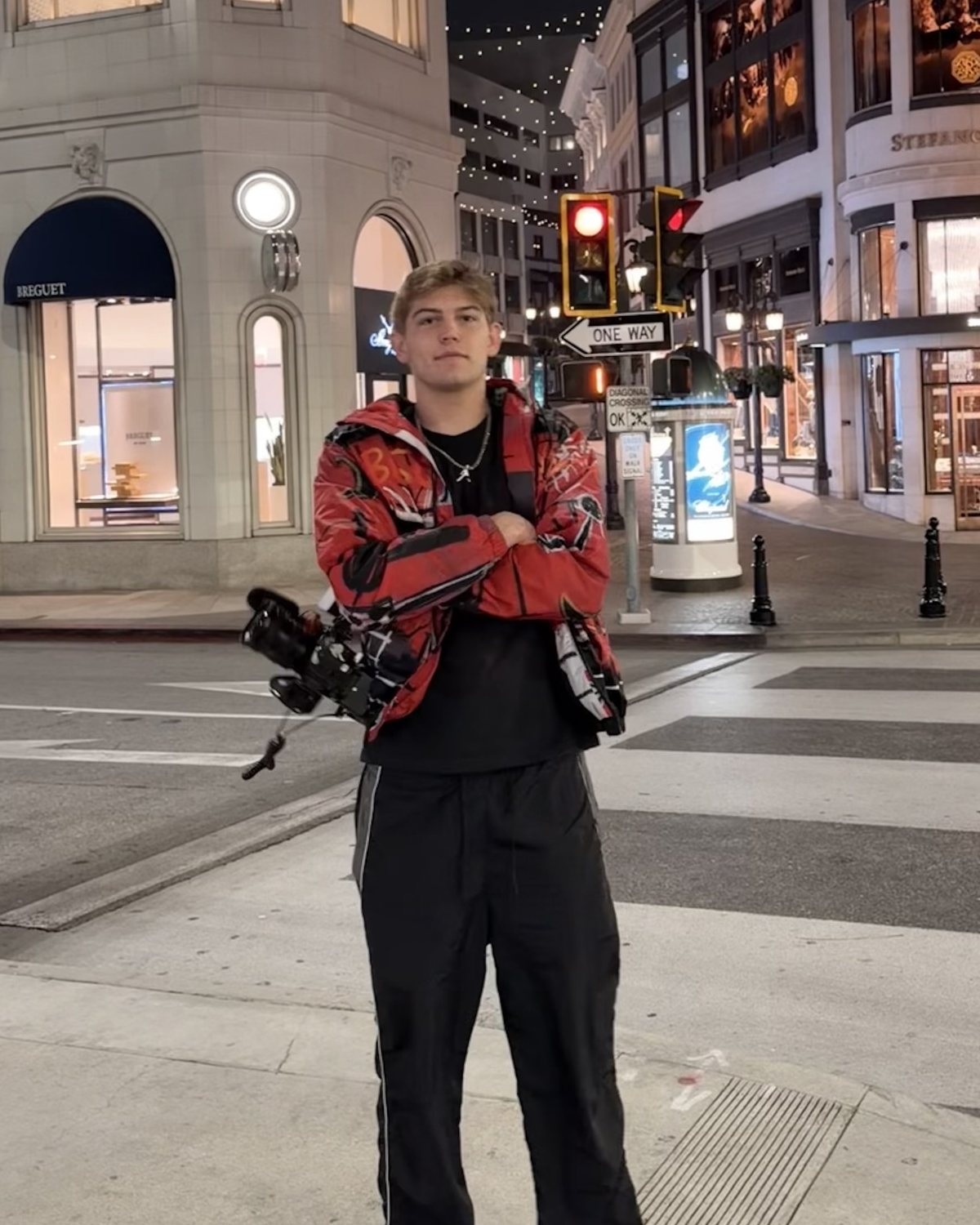 Bryson Bejerano at night, arms crossed, holding his camera rig